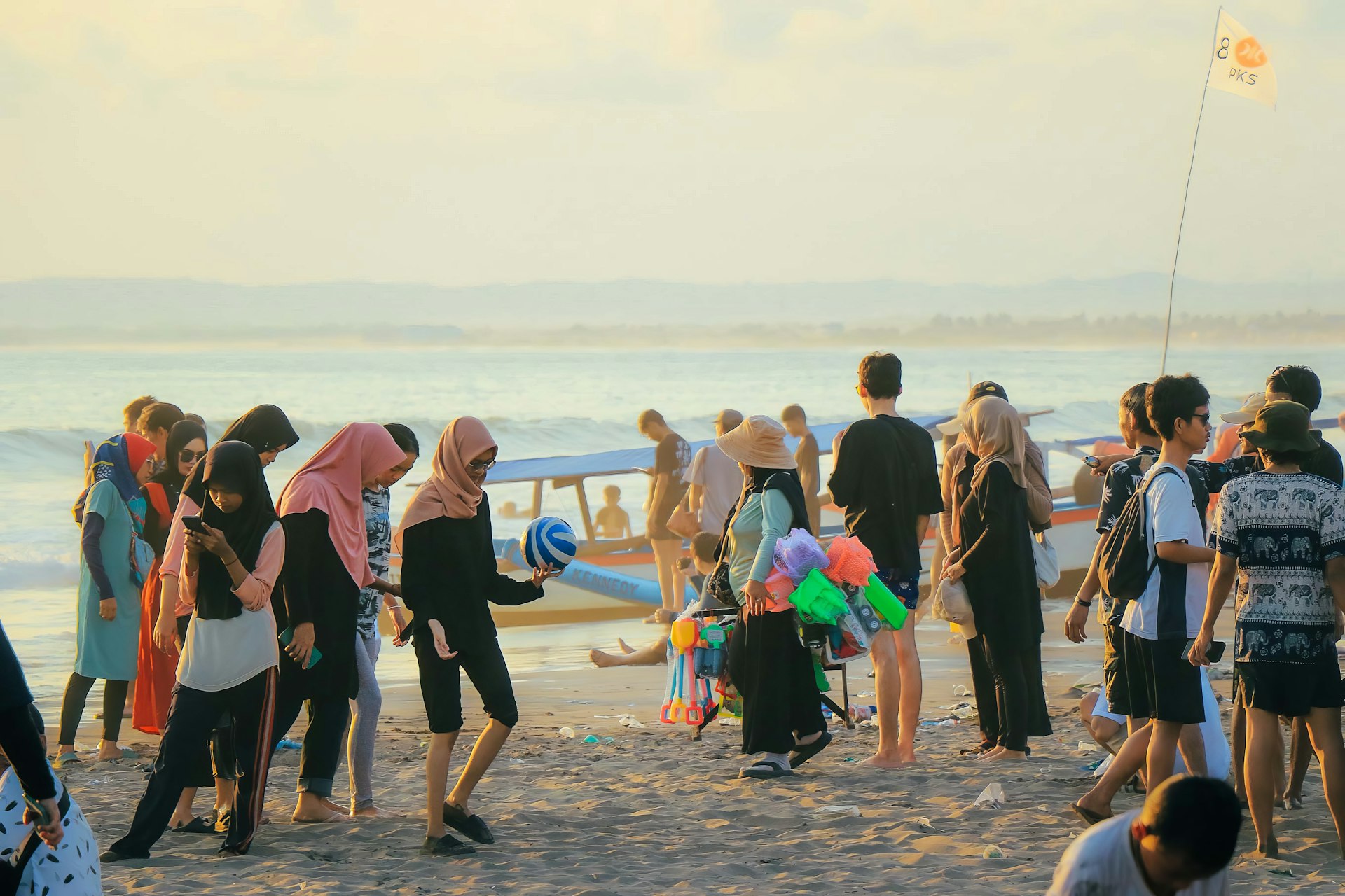 a group of people standing on top of a sandy beach